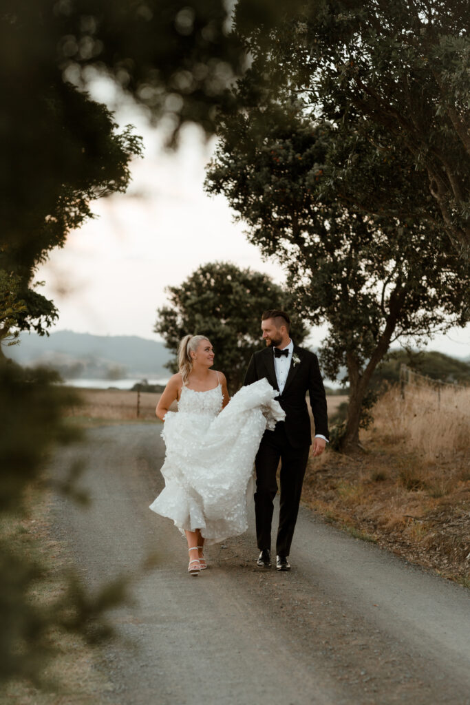 Couple walking together down a driveway at The Mc Callum Residence in Clevedon.